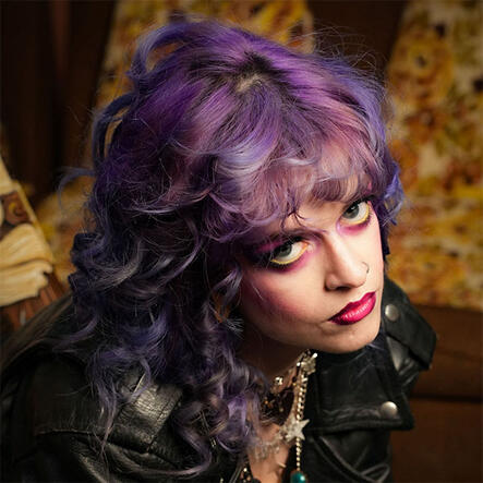 Hair for Eras Photoshoot Model with vibrant purple styled hair